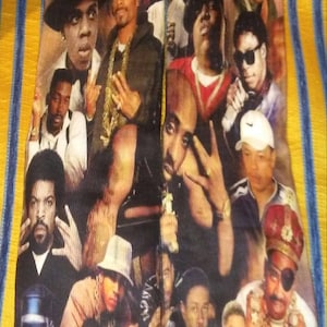 Puede incluir: Un par de calcetines coloridos con un collage de imágenes de famosos raperos. Los calcetines presentan una variedad de imágenes, incluyendo retratos de los raperos, así como imágenes de ellos actuando y posando. Los calcetines son una gran manera de mostrar tu amor por el hip hop.