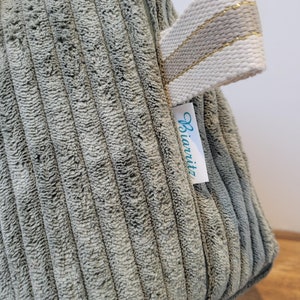 Grande trousse de toilettes imperméable en velours côtelé vert sauge. Milia-Loka Biarritz.
