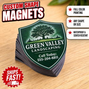 May include: A stack of shield-shaped magnets featuring a dark green background with a tree illustration and the text Green Valley Landscaping, Call Today: 555-204-8811. The magnets are displayed with text overlays highlighting full color printing.