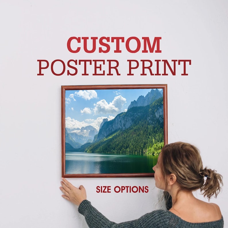 K&ouml;nnte beinhalten: Ein gerahmter Poster-Druck einer Bergsee-Szene mit einem Holzrahmen. Der Poster-Druck zeigt einen See, der von Bergen und B&auml;umen umgeben ist. Der Text "CUSTOM POSTER PRINT" befindet sich &uuml;ber dem Bild und der Text "SIZE OPTIONS" unter dem Bild.