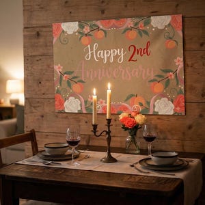 Peut inclure: Une banni&egrave;re murale rectangulaire portant l'inscription Happy 2nd Anniversary en lettres blanches et rouges. Le motif pr&eacute;sente des illustrations de p&ecirc;ches orange, de feuilles vertes et de roses blanches et rouges sur un fond beige.