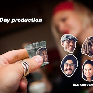 May include: A clear plastic shot glass with a photo of a woman's face inside. The shot glass is being held by a hand. There are five other photos of people's faces on the background, each with a white border. The text "Next Day production" is at the top of the image. The text "ONE FACE PER ORDER" is at the bottom of the image.