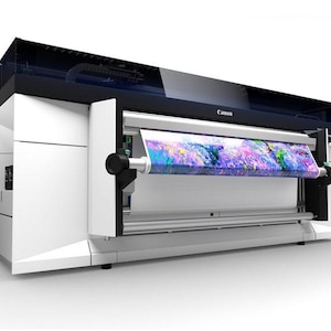 K&ouml;nnte beinhalten: Ein wei&szlig;er Canon-Gro&szlig;formatdrucker mit einer Rolle bunten Stoffes, die in den Drucker eingezogen wird. Der Drucker hat eine schwarze Oberseite und ein Canon-Logo auf der Vorderseite.