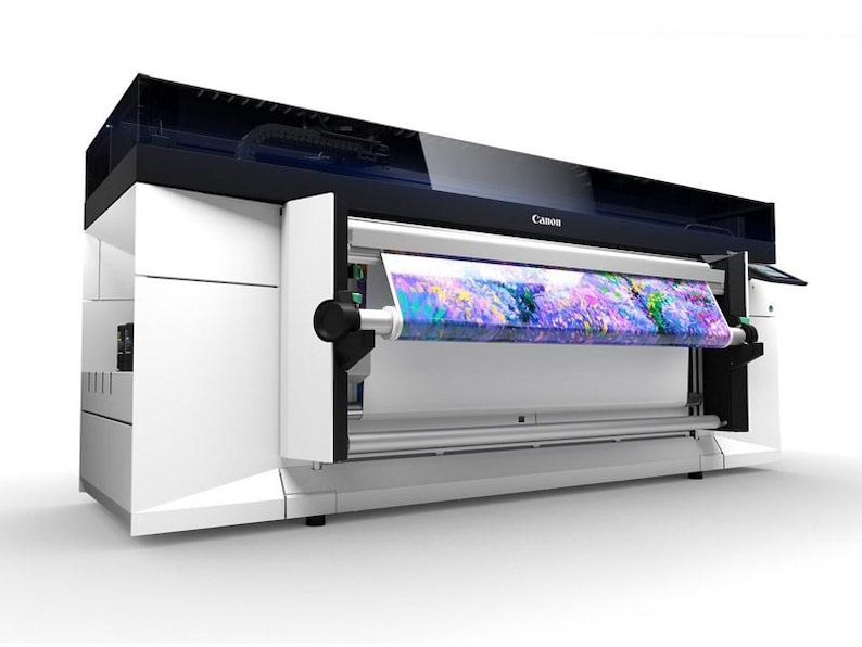 K&ouml;nnte beinhalten: Ein wei&szlig;er Canon-Gro&szlig;formatdrucker mit einer Rolle bunten Stoffes, die in den Drucker eingezogen wird. Der Drucker hat eine schwarze Oberseite und ein Canon-Logo auf der Vorderseite.