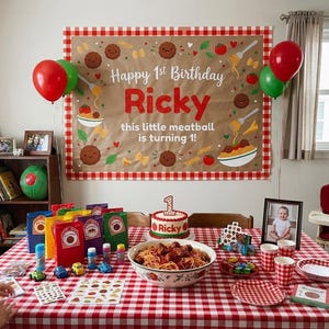 Peut inclure: Une d&eacute;coration d'anniversaire avec une grande banni&egrave;re &agrave; bordure vichy rouge portant l'inscription Happy 1st Birthday Ricky this little meatball is turning 1. La table est couverte d'une nappe vichy rouge, de spaghettis et d'un g&acirc;teau.