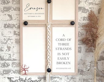 May include: A framed wall decoration with four sections. The top left section has the name "Evengon" and the date "September 14, 2024". The bottom right section has the text "A cord of three strands is not easily broken". A macrame rope detail is in the centre.