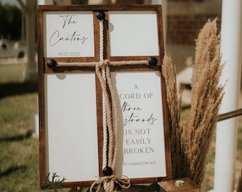 Könnte beinhalten: Ein Holzschild mit weißem Hintergrund und einem geknoteten Seil. Das Schild zeigt "The Cantons 10.12.2022" und "A cord of three strands is not easily broken. Ecclesiastes 4:12".