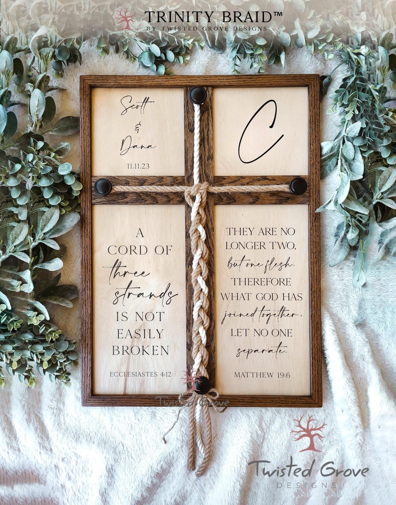 May include: A wooden sign with a trinity braid, featuring the text "A cord of three strands is not easily broken" and "They are no longer two, but one flesh. Therefore what God has joined together, let no one separate." The sign also includes the names "Scott & Dana" and the date "11.11.23".