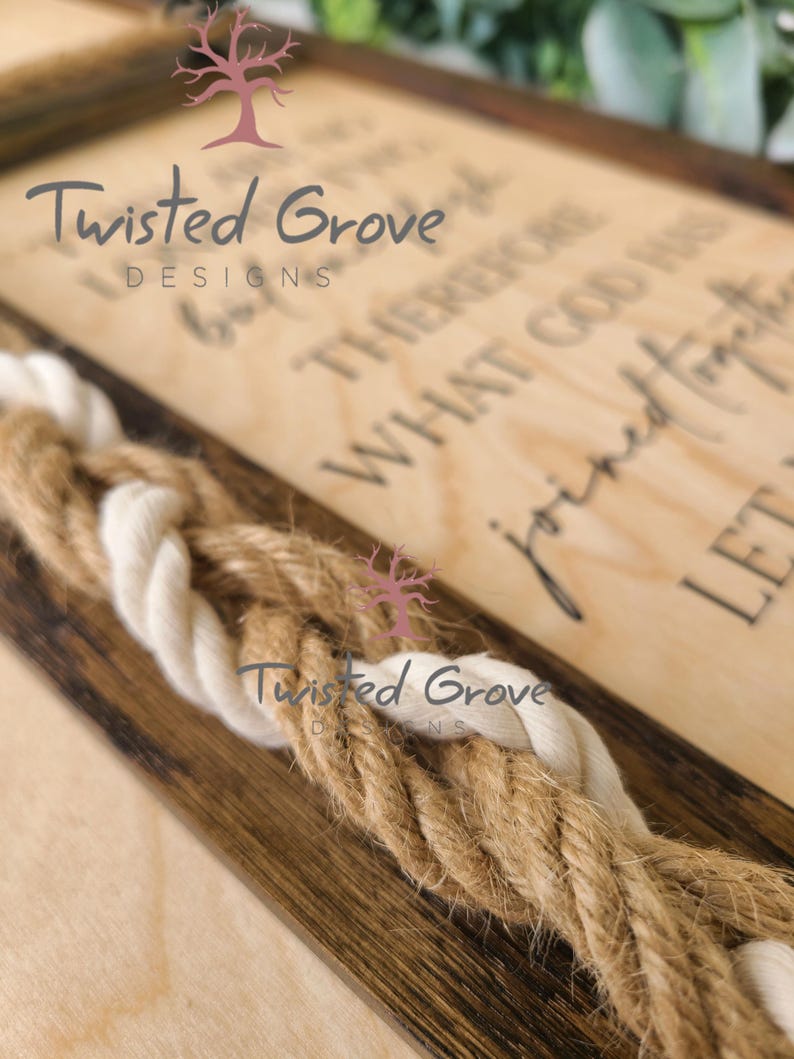 May include: A wooden sign with the text "Twisted Grove Designs" and the quote "I believe therefore I am. What God has joined let no man tear apart." The sign is decorated with a brown and white rope.