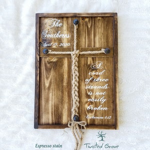 May include: A wooden sign with a cross made of rope, stained espresso brown. The sign reads "The Southerns, April 10, 2020" and "A cord of three strands is not easily broken, Ecclesiastes 4:12". The sign is made by Twisted Grove Designs.