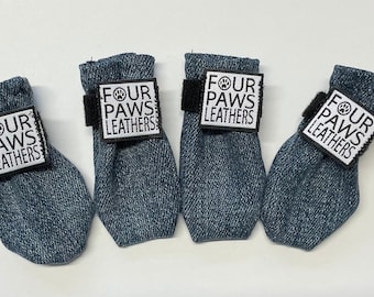Könnte beinhalten: Vier blaue Denim-Hundestiefel mit schwarzen Klettverschlüssen und weißen "Four Paws Leathers" -Patches.