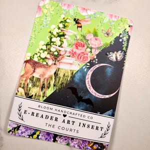 May include: A rectangular e-reader art insert featuring a split design. The left side shows a deer, a fountain, flowers, and a bee on a light green background. The right side depicts a crescent moon, a moth, and a bat on a dark blue background.