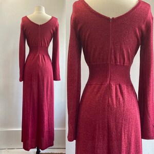 May include: A long-sleeved, burgundy maxi dress with a fitted bodice and a slightly flared skirt. The dress is made of a soft, knit fabric with a subtle shimmer.