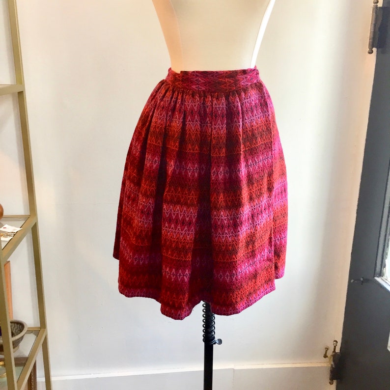 May include: A red and pink patterned skirt with a high waist and a flared silhouette.