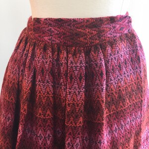 May include: A red, pink, and black patterned skirt with a gathered waist.