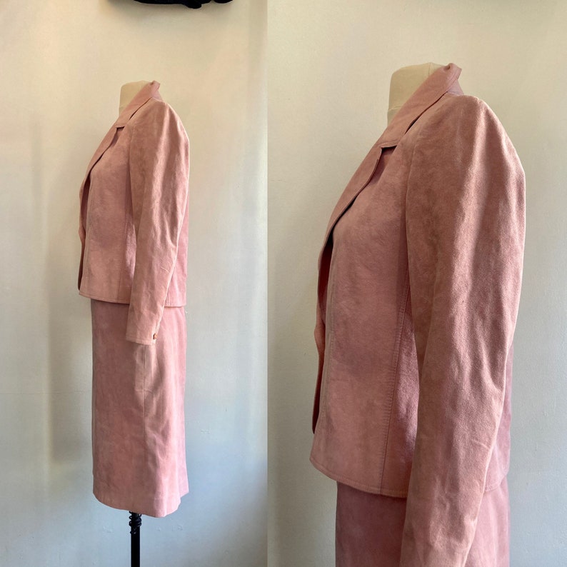 May include: A pink suede skirt suit with a long-sleeved jacket and a knee-length skirt.