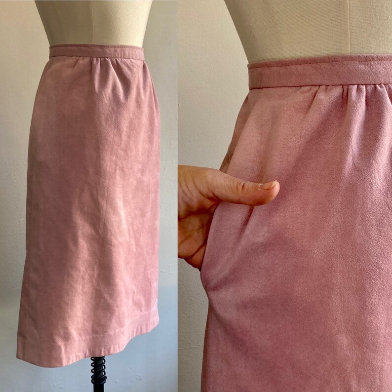 May include: A dusty rose suede skirt with a straight, fitted silhouette. The skirt has a simple design with a waistband and a smooth, textured surface.