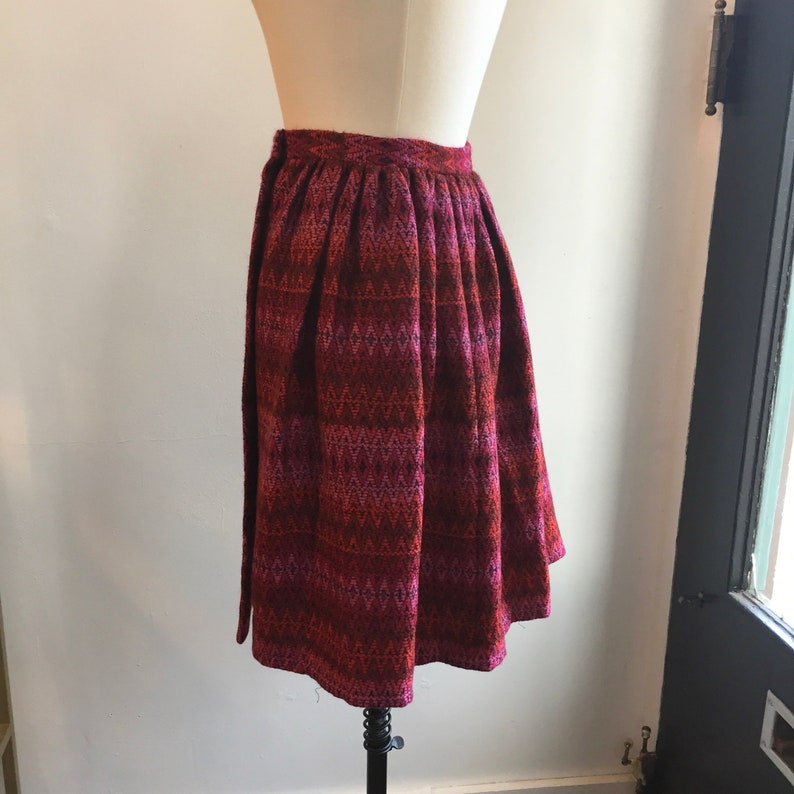 May include: A red, pink, and black patterned skirt with a gathered waist.