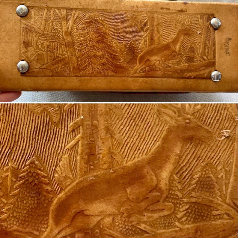 Pode incluir: Um item de couro castanho com uma cena de floresta esculpida com um veado e &aacute;rvores. O design &eacute; detalhado e o item tem tachas de metal nos cantos. A palavra "Mexico" &eacute; vis&iacute;vel na lateral.
