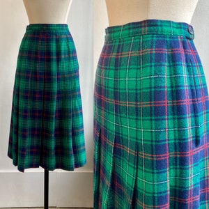 May include: A green, blue and red plaid pleated skirt. The skirt is knee-length and has a high waist.
