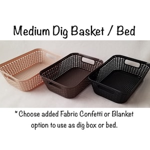 May include: Three plastic storage baskets in beige, brown, and black. The baskets are woven and have a rectangular shape with handles on the sides. The text "Medium Dig Basket / Bed" is at the top of the image. The text "* Choose added Fabric Confetti or Blanket option to use as dig box or bed." is at the bottom of the image.