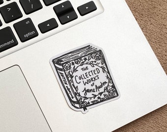 May include: A black and white sticker of a book with the text "The Collected Works of Jane Austen" on a silver laptop.