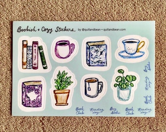 May include: A sheet of stickers featuring illustrations of books, teacups, and plants. The stickers are on a light blue background and have text that says "Bookish + Cozy Stickers" and "Book Reading Buys".