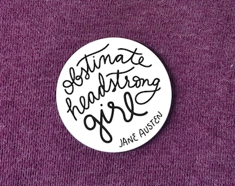 May include: White round sticker with black text that reads "obstinate headstrong girl" and "JANE AUSTEN" in a smaller font.