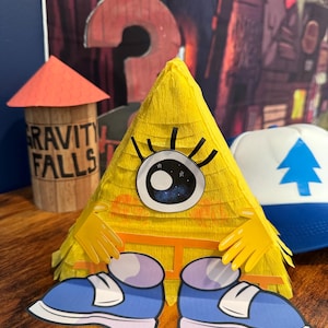 May include: A yellow triangular figure with a large eye, yellow gloves, and blue shoes. The figure is a piñata. A wooden tower with the words "GRAVITY FALLS" is in the background, along with a blue and white hat with a tree.
