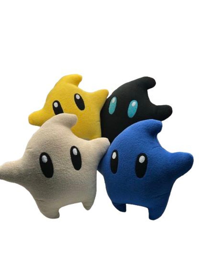 May include: Four star-shaped plush toys in yellow, black, blue, and beige. Each star has large, oval eyes with white highlights. The toys are soft and made of a fuzzy material. Ideal for fans of video games.