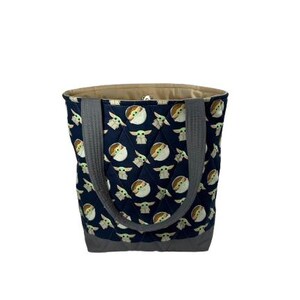 May include: A navy blue quilted tote bag featuring a repeating pattern of a character from a popular science fiction series. The bag has gray handles and a gray bottom. The interior is a light tan color.