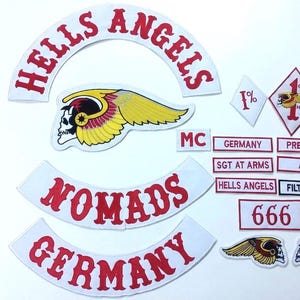 May include: A collection of embroidered patches including a large arched Hells Angels rocker, a winged skull emblem, and smaller rectangular patches with text such as Germany, President, Sgt at Arms, AFFA, Filthy Few, and the number 666 in red and white.