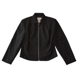 Könnte beinhalten: Schwarze Jacke mit Reißverschluss, dezentem Karomuster und kleinem Kragen. Die Jacke hat lange Ärmel und einen silbernen Reißverschluss. Der Markenname "MISIE" ist auf einem kleinen Etikett am Kragen sichtbar. Vielseitig einsetzbar.