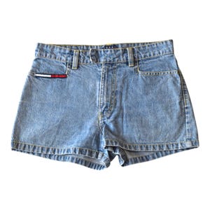 Peut inclure: Shorts en jean bleu clair avec une conception classique à cinq poches. Comprend une petite poche avec un accent rouge, blanc et bleu. Les shorts ont une fermeture à bouton et à glissière et une étiquette "Tommy" sur la ceinture.