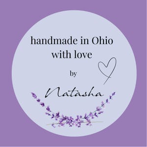 May include: A round, light purple sticker with the text "handmade in Ohio with love by Natasha." A black heart and a lavender sprig design are also included. The background is a darker shade of purple.