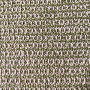 May include: Close-up of a woven fabric with a green and white checkered pattern. The fabric has a textured, slightly rough surface.