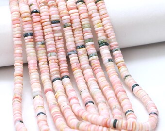 Pode incluir: Fios de contas de pedras preciosas rosa. As contas são planas, redondas e em forma de disco, com uma mistura de tons rosa, branco e verde. As contas são enfiadas, criando um visual fluido e orgânico. As contas são provavelmente usadas para fazer joias.