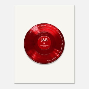May include: A circular red vinyl record featuring white text printed on the surface. The center label displays the letters J&B, the phrase "Happily ever after", and a date. The outer edge includes the text "A short lyric or phrase from your special song or any text you like special song".