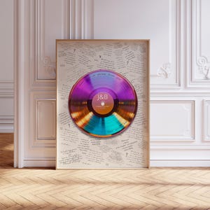 May include: A framed print featuring a central iridescent vinyl record with a purple and gold center label displaying the text J&B. The background is filled with repeated handwritten messages wishing a lifetime of love, laughter, and memories.
