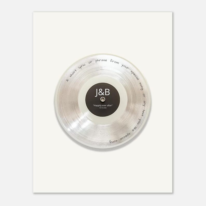May include: A clear vinyl record with a black center label featuring the white text J&B and Happily ever after 10-10-2026. The transparent disc has handwritten black text along the outer edge reading A short lyric or phrase from your special song or any text you like special song.