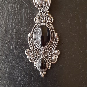 Colgante de plata 925 con filigrana y dos piedras de ónix. 
Una ovalada cabujón, la otra en forma de lágrima.
