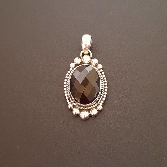 Colgante en plata de ley 925 con gema de ónix negro facetado.