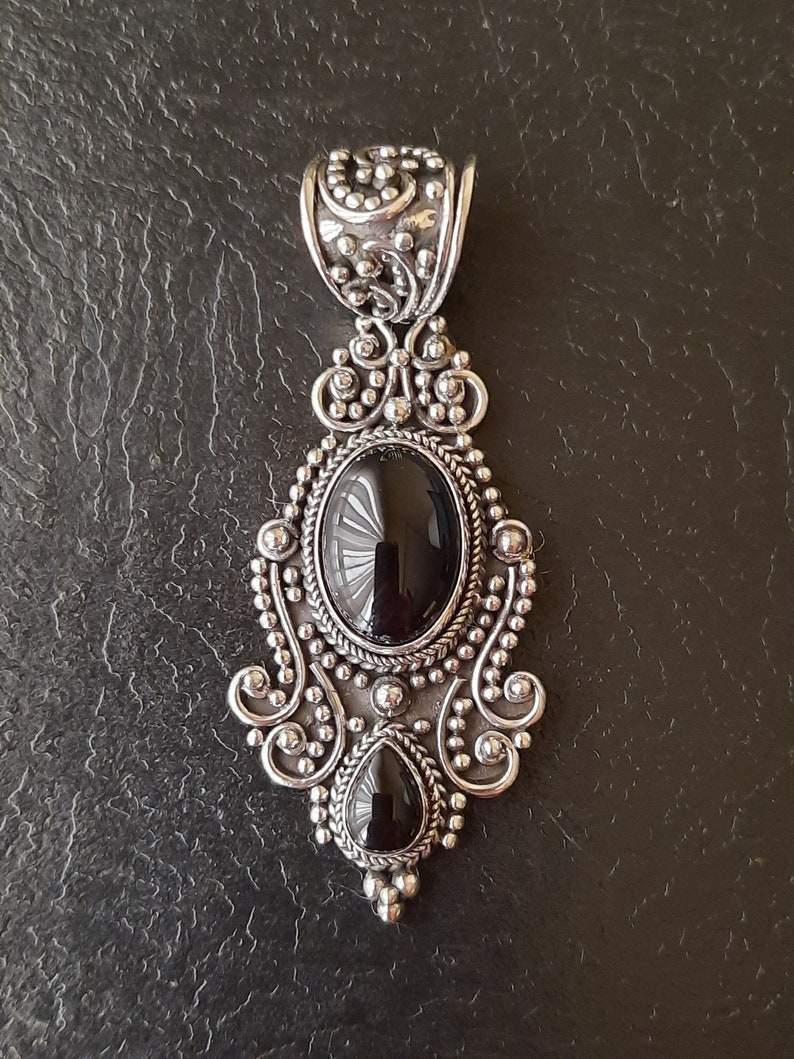 Colgante de plata 925 con filigrana y dos piedras de ónix. 
Una ovalada cabujón, la otra en forma de lágrima.