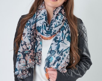 May include: A floral print scarf with a white background, teal and peach flowers, and a navy border. The scarf is draped around the neck. The scarf has a fringed edge.