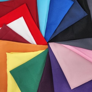 May include: A vibrant display of folded fabric samples in a circular arrangement. The color palette includes a variety of hues, such as red, white, orange, yellow, green, blue, and purple. The fabric appears to be smooth and likely suitable for sewing or crafting projects.