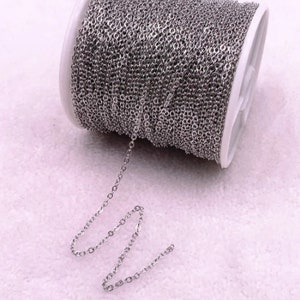 K&ouml;nnte beinhalten: Eine Spule mit silberfarbener Kette, mit einem kleinen St&uuml;ck Kette, das sich von der Spule erstreckt. Die Kette besteht aus kleinen, gleichm&auml;&szlig;ig verteilten Gliedern. Die Spule ist wei&szlig; und grau.