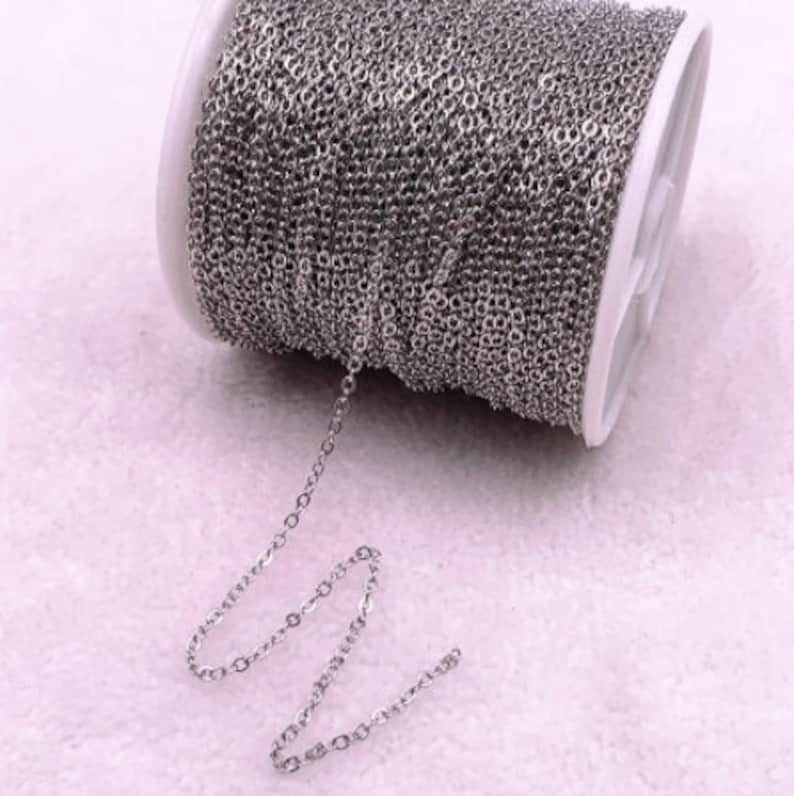K&ouml;nnte beinhalten: Eine Spule mit silberfarbener Kette, mit einem kleinen St&uuml;ck Kette, das sich von der Spule erstreckt. Die Kette besteht aus kleinen, gleichm&auml;&szlig;ig verteilten Gliedern. Die Spule ist wei&szlig; und grau.