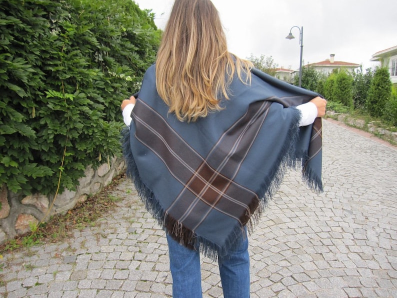 May include: A blue and brown plaid fringed shawl with a geometric pattern.