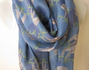 May include: A blue scarf with a pattern of sloths hanging from branches. The scarf has a fringe on the bottom.