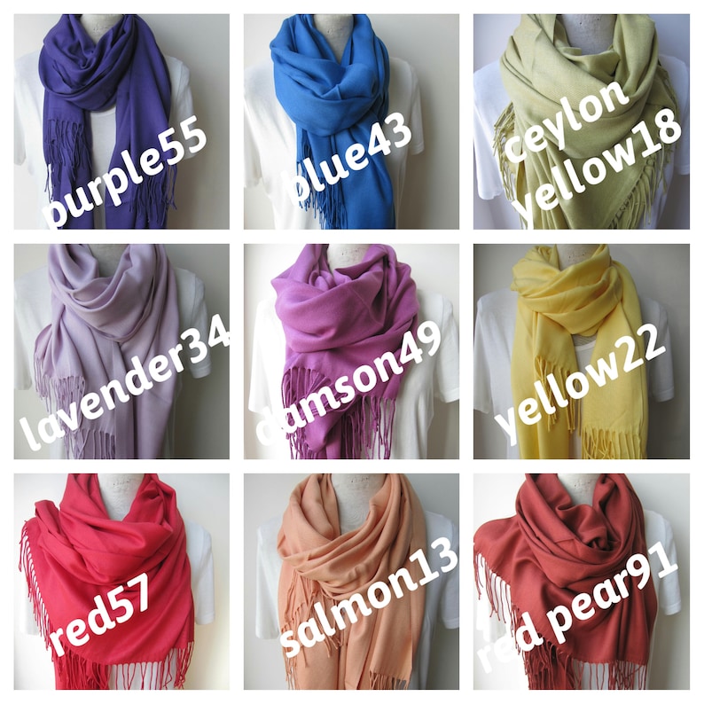 May include: Nine different colors of pashmina scarves with fringe. The colors are purple, blue, yellow, lavender, crimson, red, salmon, and red pear.